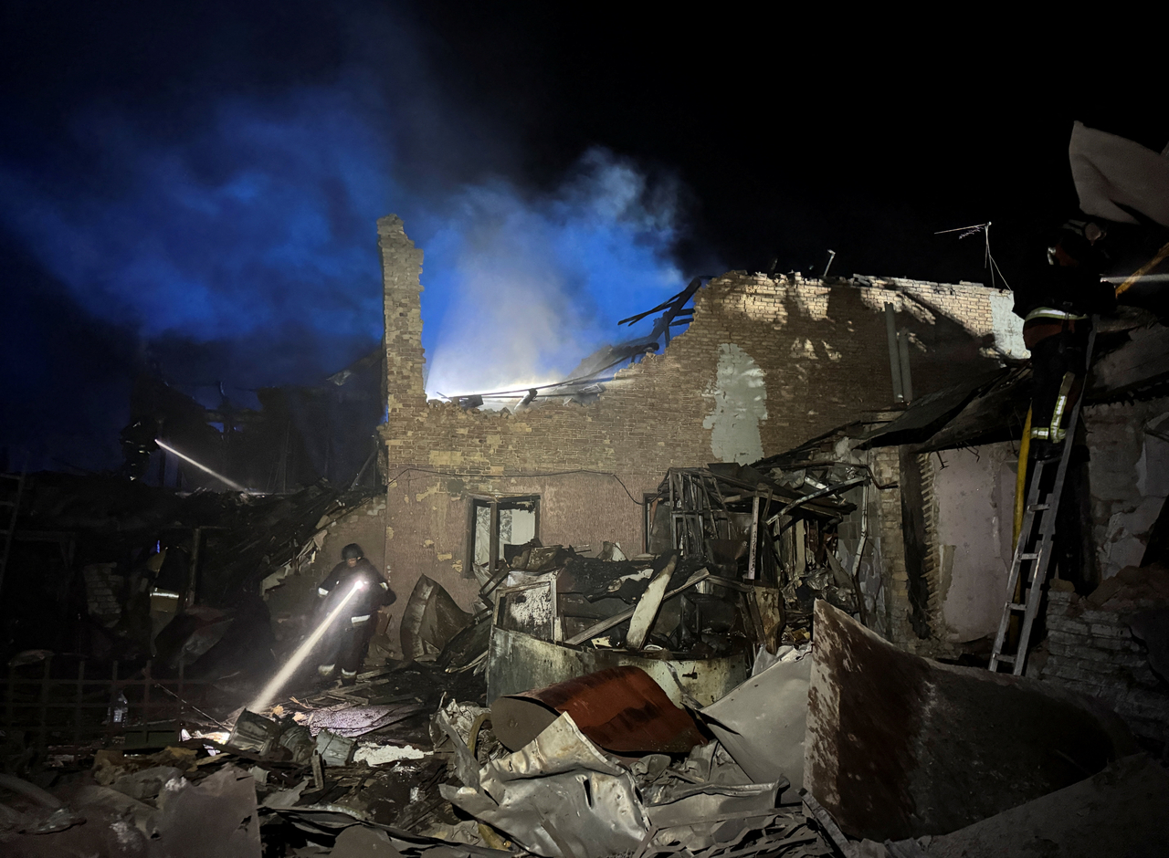 Firefighters work at the site of a building hit during a Russian missile strike, amid Russia's attack on Ukraine, in Zaporizhzhia, Ukraine, Tuesday. (Reuters-Yonhap)