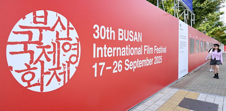 제30회 부산국제영화제(BIFF) 개막을 이틀 앞둔 15일 부산 해운대구 영화의전당 앞에 설치된 포스터 앞으로 시민이 지나가고 있다. 윤병찬 기자