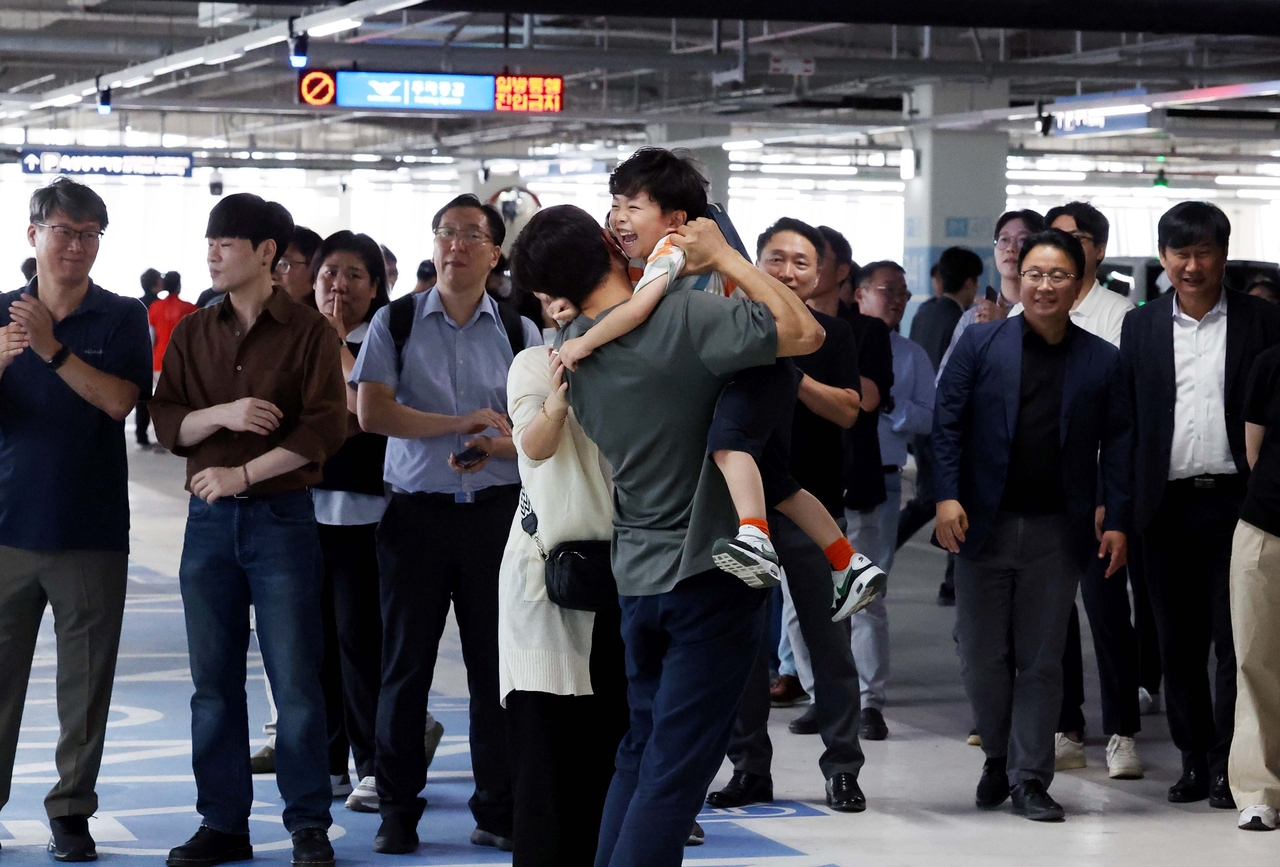 South Korean workers who had been detained by US immigration authorities in Georgia reunite with their families at a parking lot of Terminal 2 at Incheon International Airport on Friday. (Yonhap)