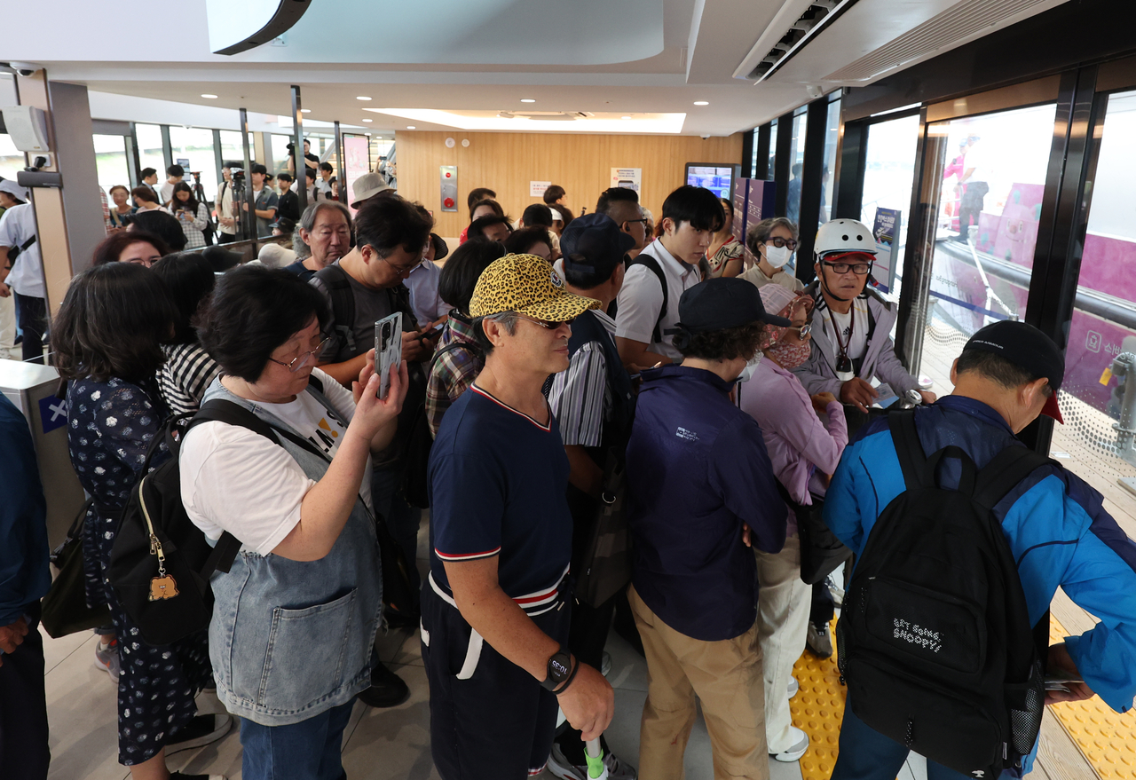 Passengers wait to board the Hangang Bus at Jamsil Pier in Seoul on Friday, the first day of its official service.  (Yonhap)