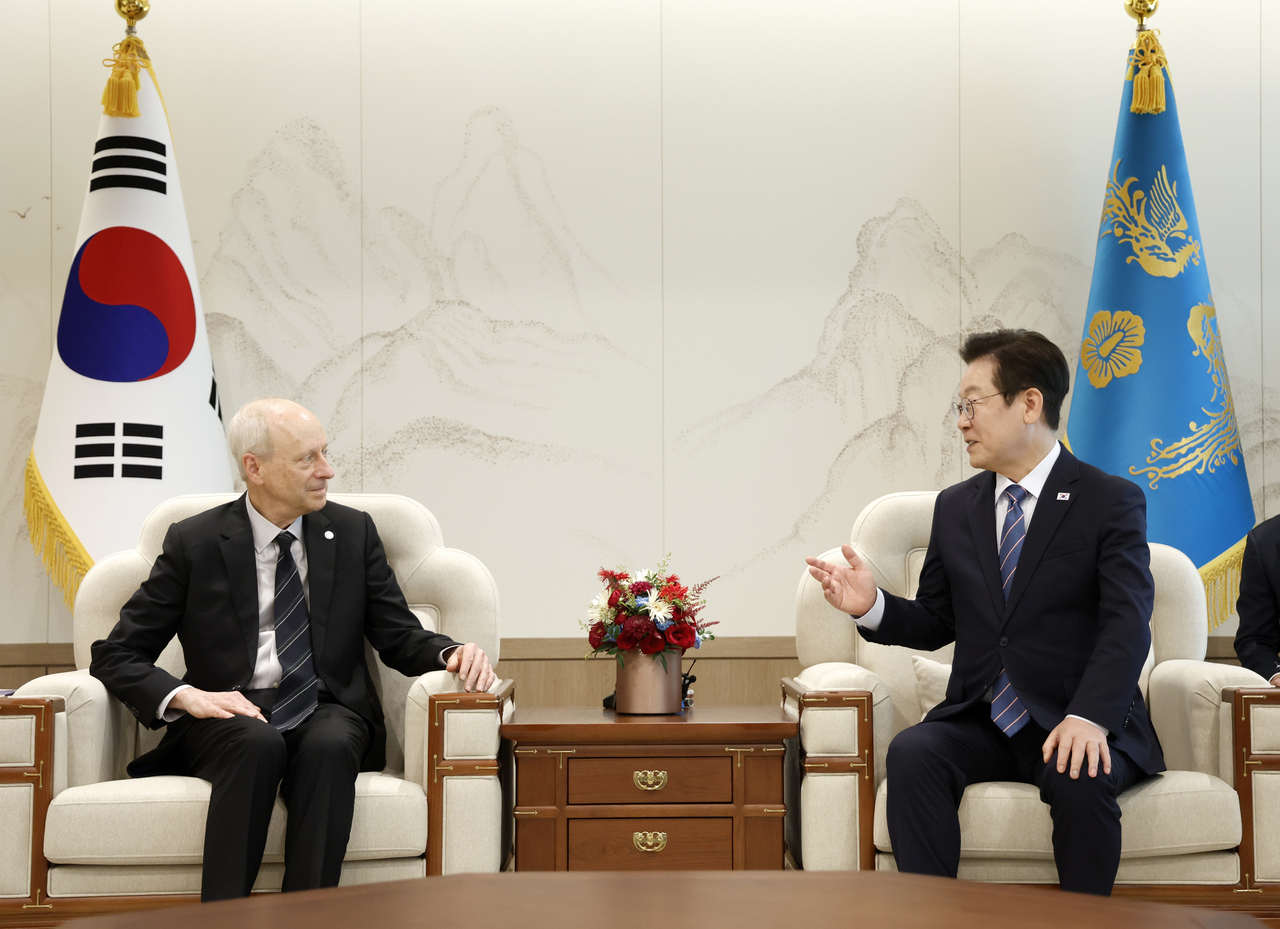 President Lee Jae Myung (right) speaks with Harvard professor Michael Sandel at the Presidential Office in Yongsan, Seoul, on Thursday. (Yonhap)