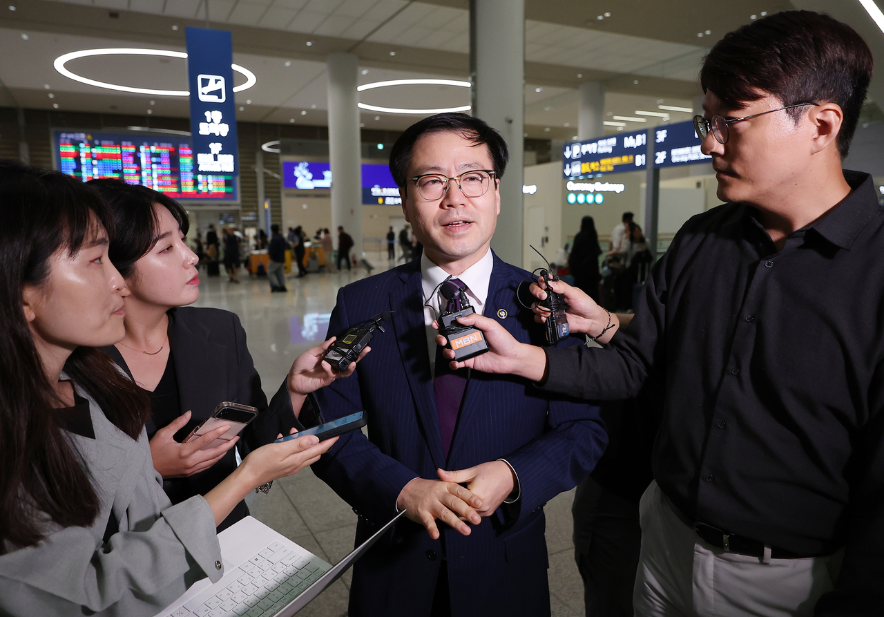 South Korean Trade Minister Yeo Han-koo (center) answers reporters' questions upon arriving at Incheon Airport on Friday. (Yonhap)