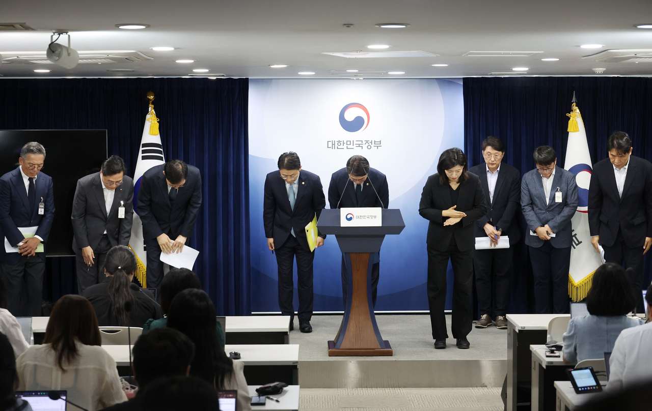 Officials from the Ministry of Science and ICT, the Financial Services Commission,  KT Corp. and Lotte Card bow in apology over a recent series of hacking incidents during a joint press briefing held in Seoul on Friday. (Yonhap)