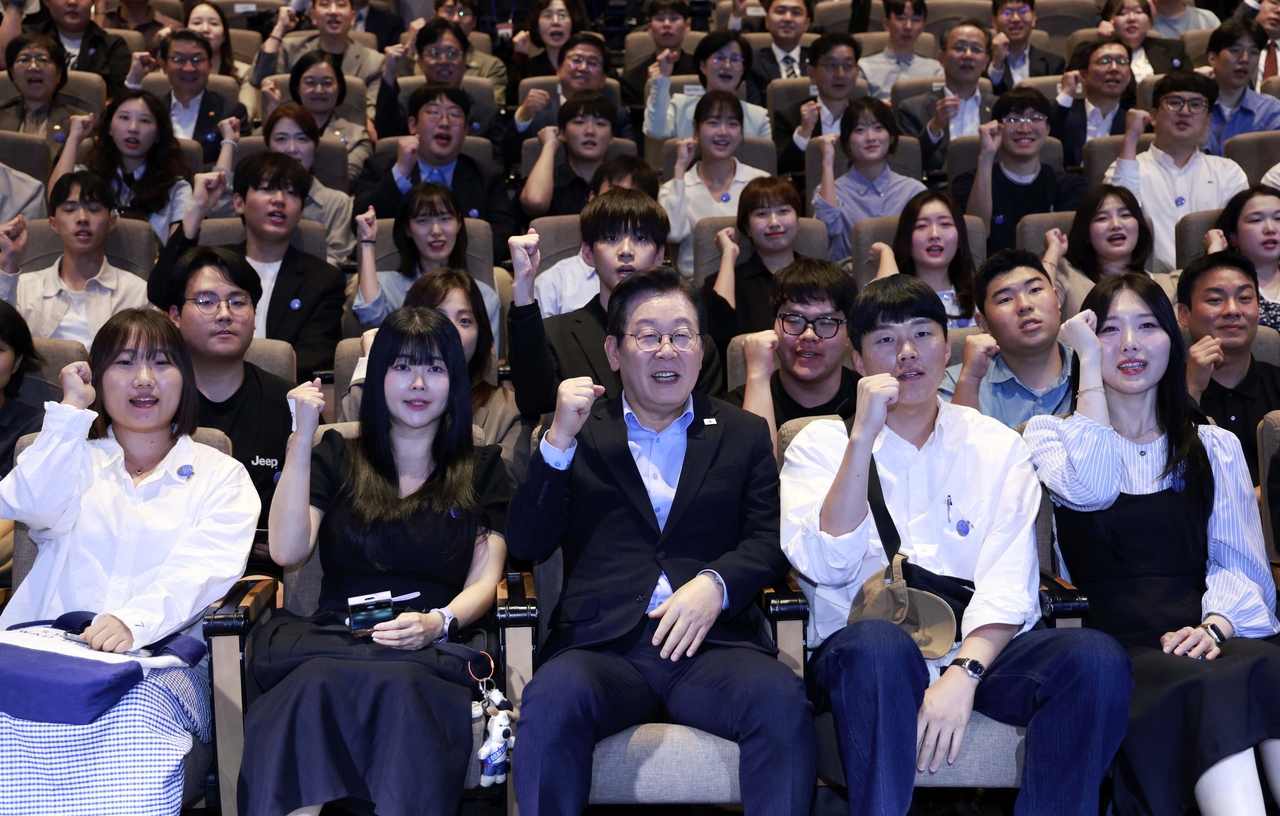 President Lee Jae Myung poses with participants at an event with people in their 20s and 30s held at a theater in Seoul on Sept. 19, 2025. (Yonhap)