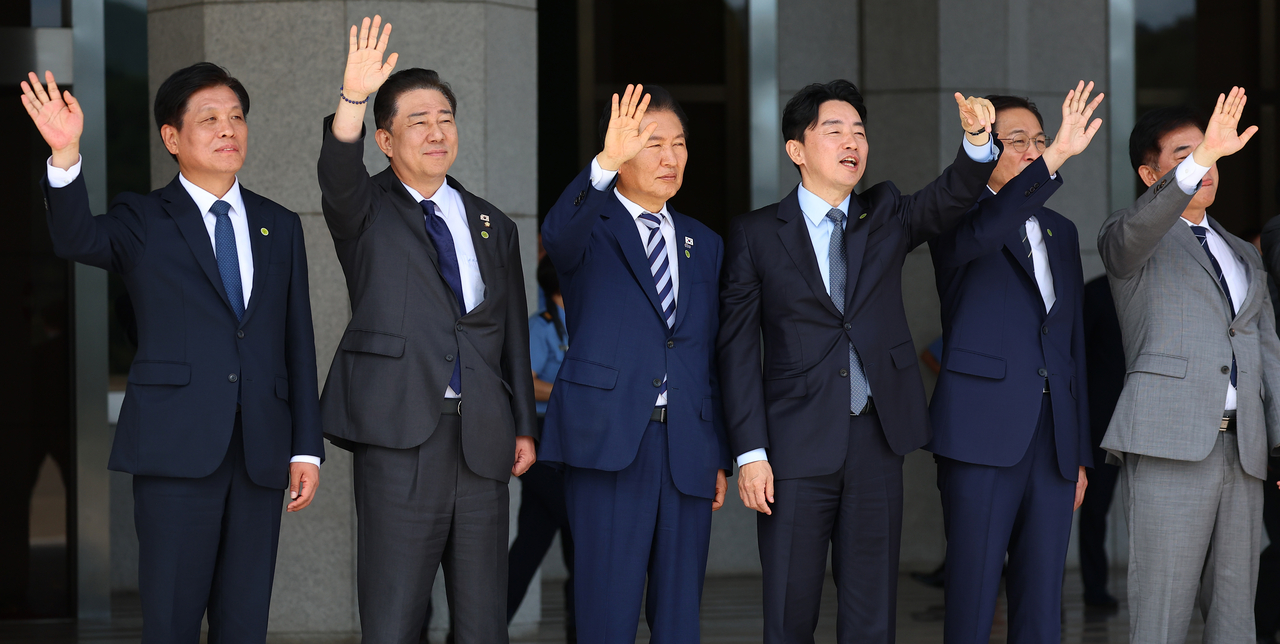 강훈식(왼쪽에서 네번째) 대통령 비서실장이 22일 성남 서울공항에서 유엔총회 참석차 출국하는 이재명 대통령과 김혜경 여사가 탑승한 공군 1호기를 향해 손을 흔들고 있다. [연합]