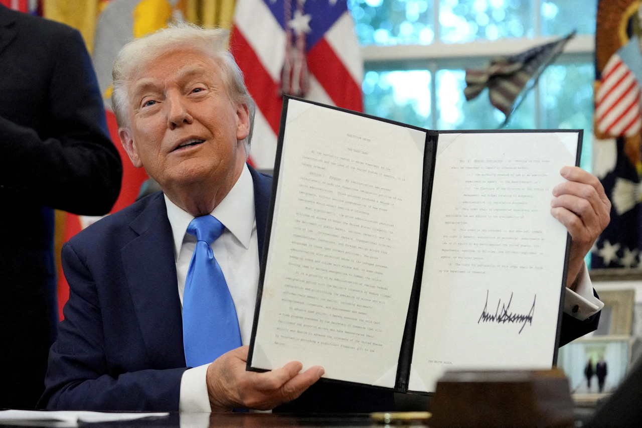 US President Donald Trump displays a signed executive order on gold card visa in the Oval Office at the White House in Washington on Friday.   Reuters-Yonhap
