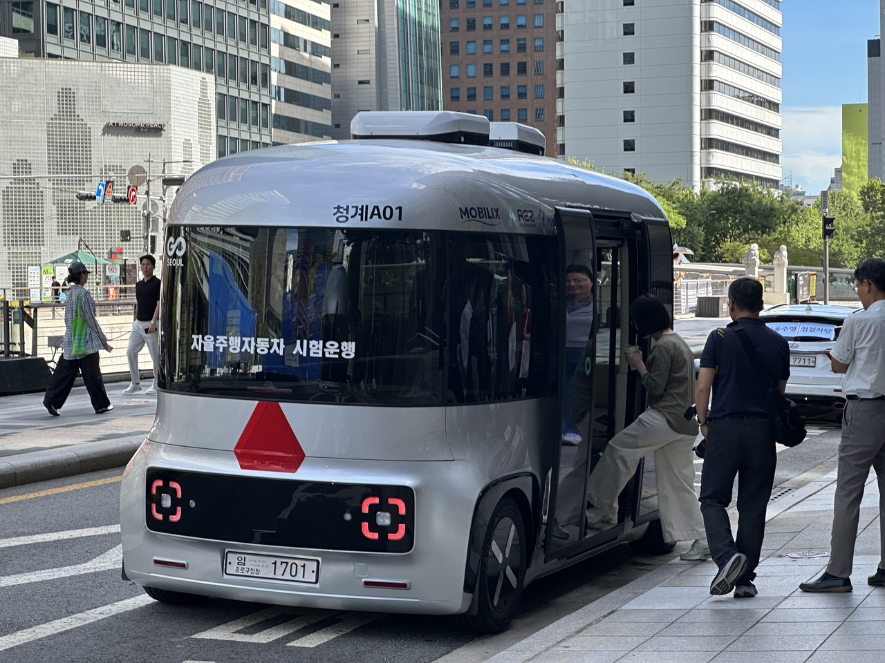 Passengers board the self-driving bus parked on a street near Cheonggyecheon in Jongno-gu, central Seoul, Tuesday. (Lee Jung-joo/The Korea Herald)