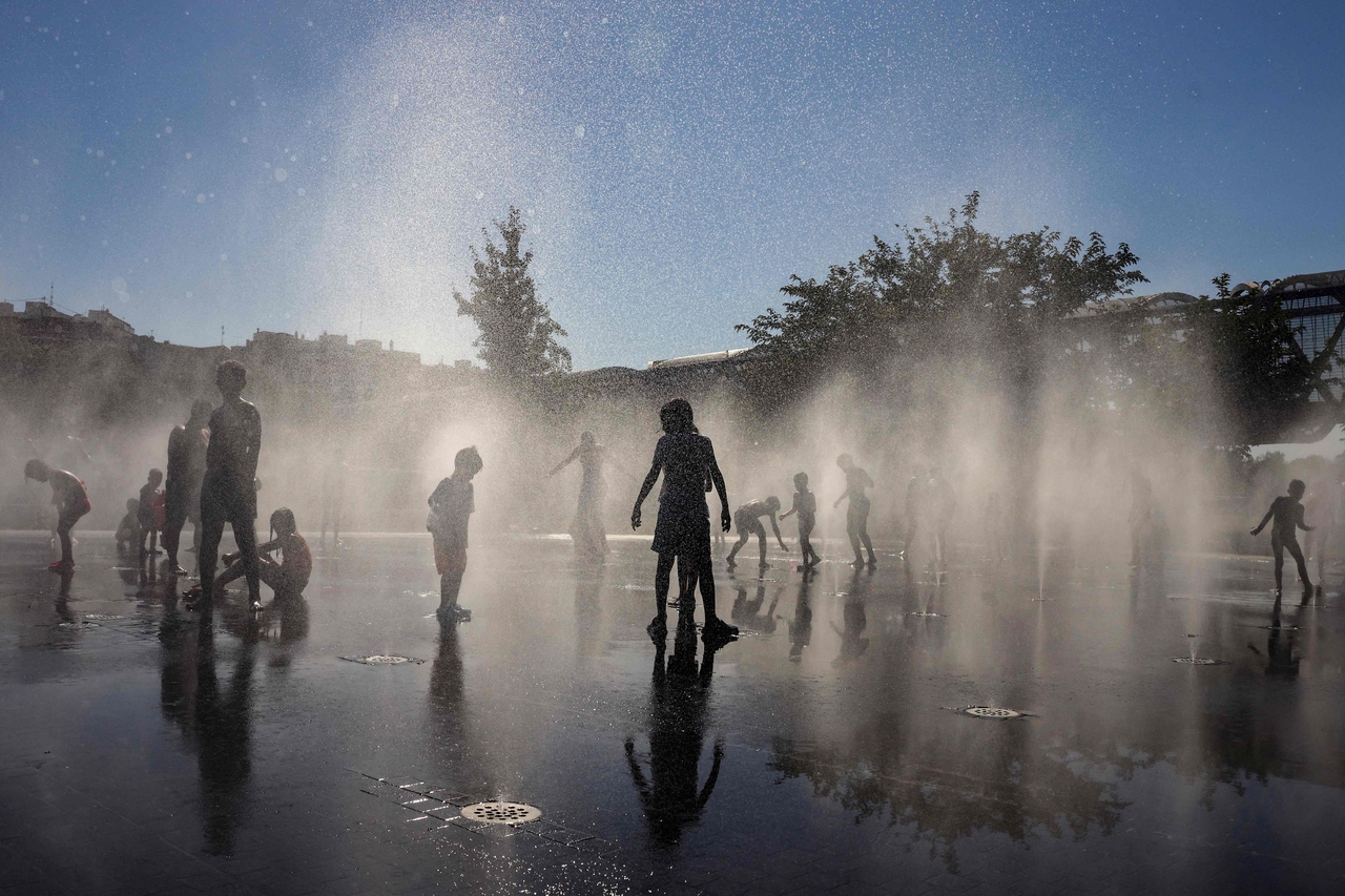 People cool off at a fountain in the Madrid Rio park amid heat wave conditions in Madrid in July 2024. (AFP-Yonhap)