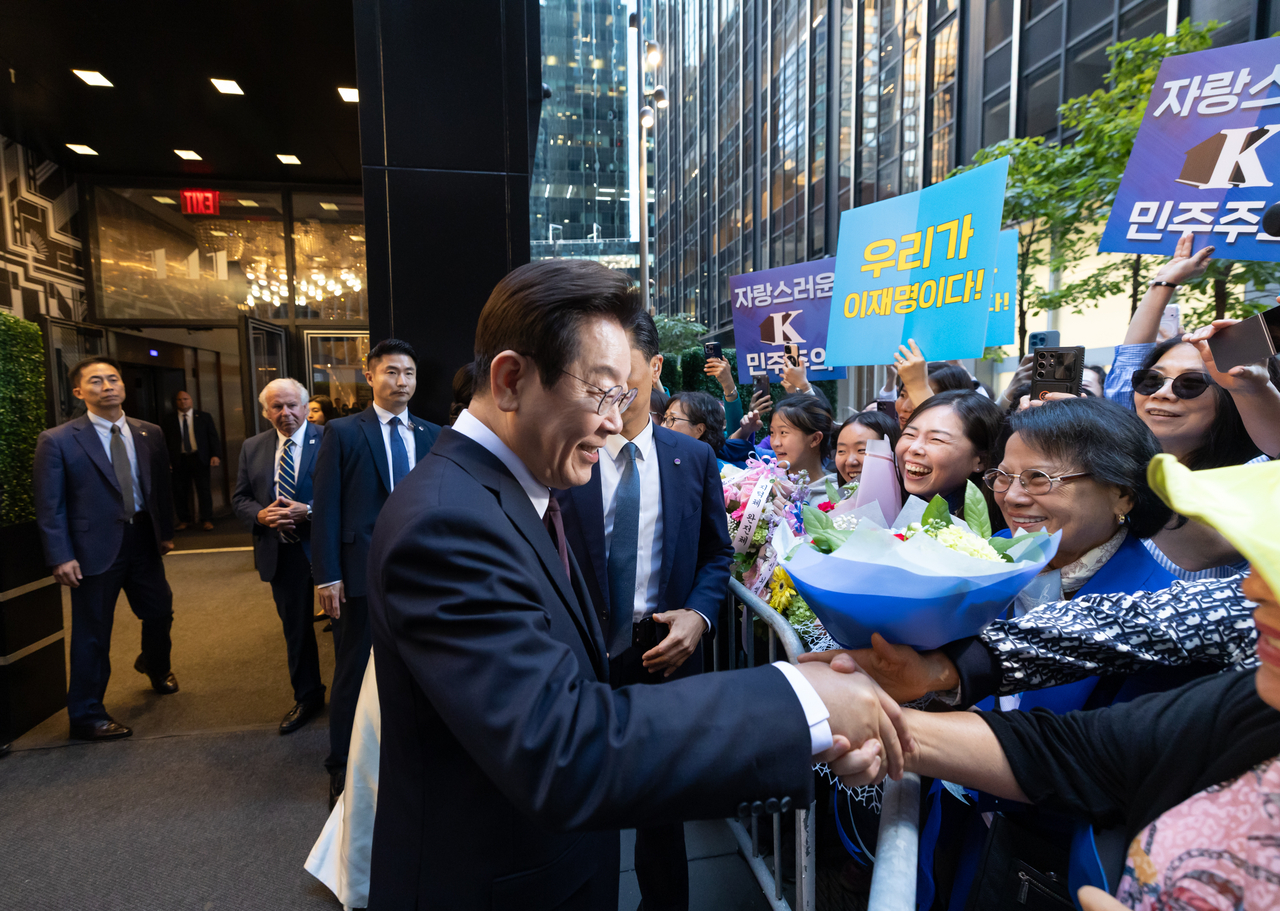 President Lee Jae Myung (center, front) is greeted by overseas Koreans at an event in New York Monday. (Pool photo via Yonhap)
