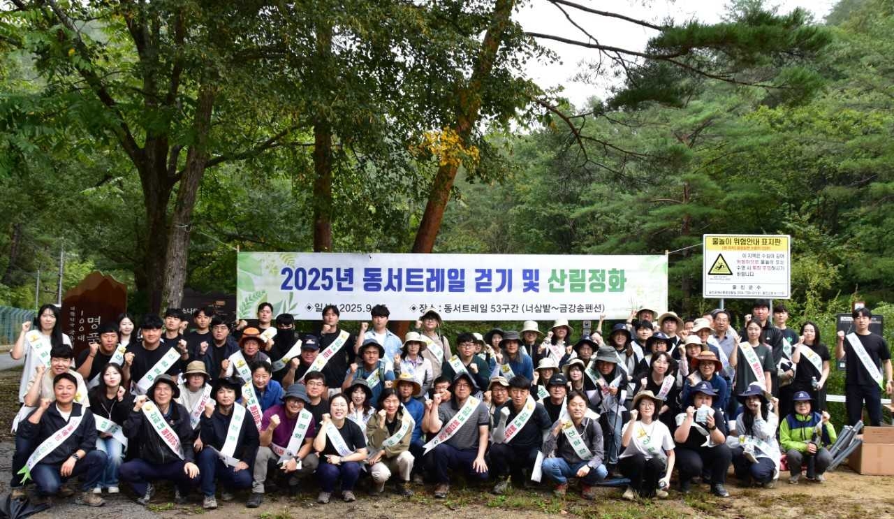 동서트레일 걷기 및 산림정화 활동 참가자들이 단체 기념사진을 찍고 있다.[남부지방 산림청제공]