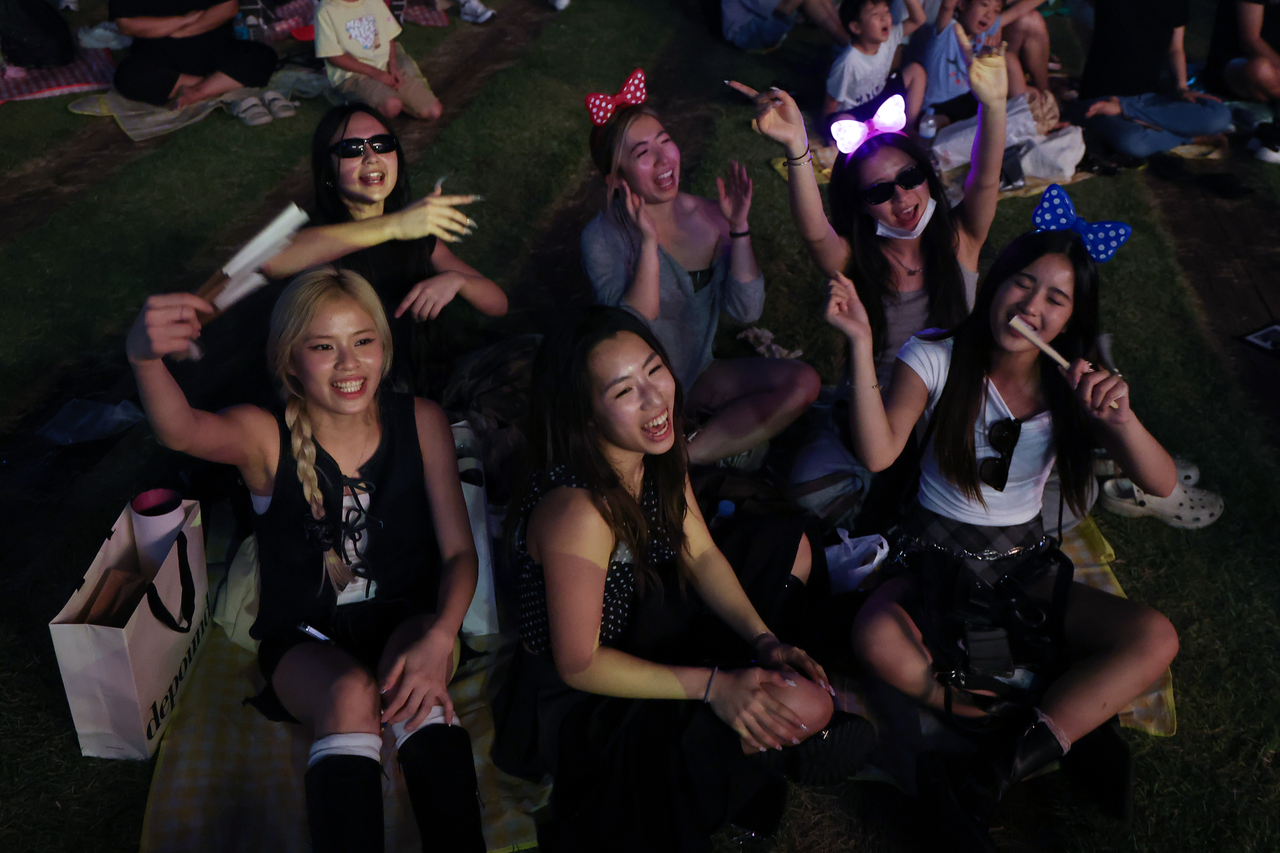Tourists take part in a sing-along event for "KPop Demon Hunters" at Seoul Square on Sept. 14. (Yonhap)