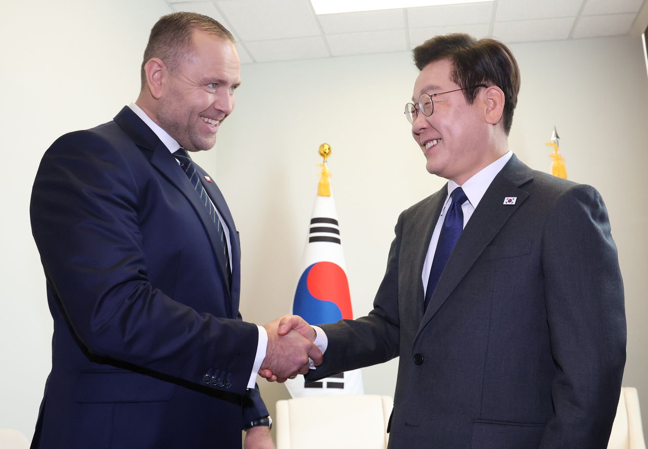 President Lee Jae Myung (right) and Poland's President Karol Nawrocki shake hands during the meeting at the UN headquarters in New York on Wednesday. (Yonhap)