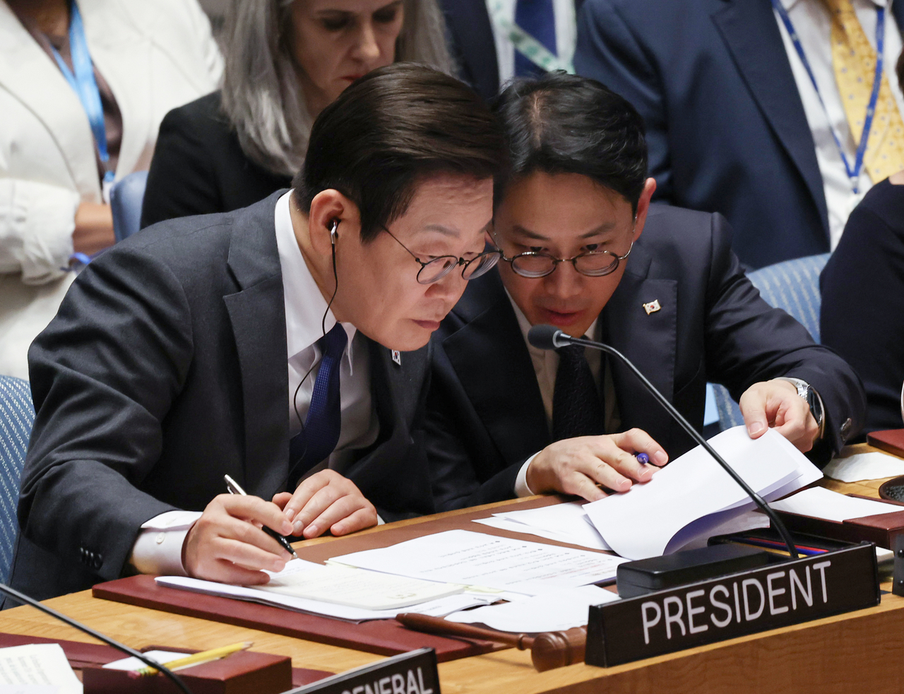 President Lee Jae Myung (left) is seen with his interpreter at a United Nations Security Council high-level open debate he chaired at the UN headquarters in New York on Wednesday. (Yonhap)