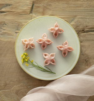 Pink hydrangea-shaped Korean rice cakes arranged on a serving plate