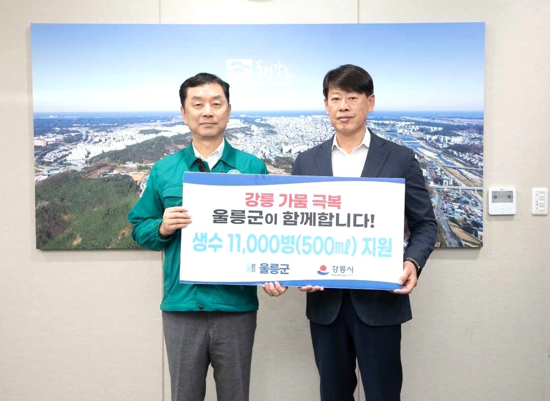 임장혁울릉군 기획감사실장(오른쪽)이 김상영 강릉시 부시장에게 울릉도의 청정 먹는샘물 ‘울림수’ 1만1000 병을 잔달하고 있다.[울릉군 제공]