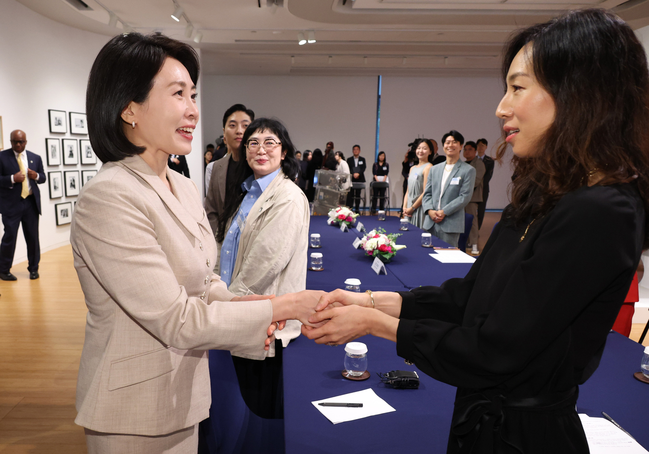 First lady Kim Hea Kyung (left) shakes hands with singer-songwriter Lee So-eun during a roundtable with young artists based in New York during their meeting at the Korean Cultural Center New York on Wednesday. (Yonhap)