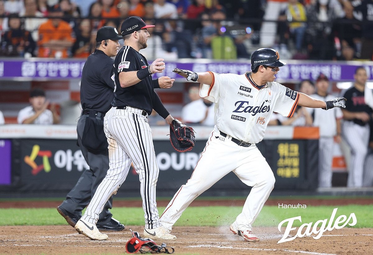 Hanwha Eagles의 Roh Si-hwan (오른쪽)은 금요일 서울 남쪽의 140 킬로미터의 Daejeon Hanwha Life Ballpark의 LG 쌍둥이와의 한국 야구 단체 정기 시즌 경기에서 홈 플레이트를 건너는 후 안전한 제스처를 만듭니다. (yonhap)