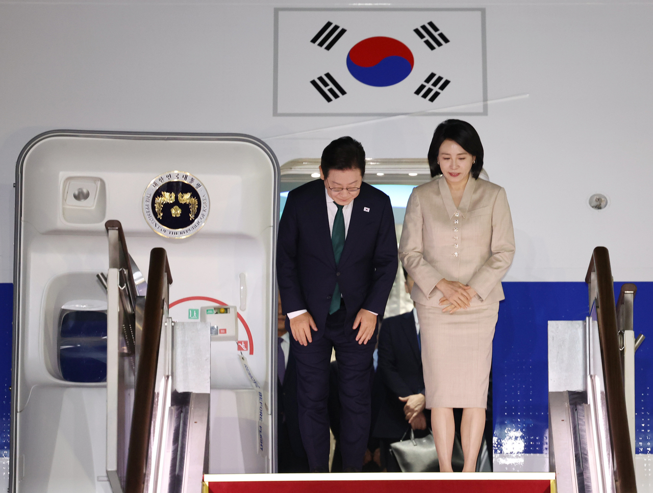 PResident Lee Jae Myung (left) and first lady Kim Hea Kyung arrive at the Seoul Air Base in Seongnam, Gyeonggi Province, on Friday. (Yonhap)