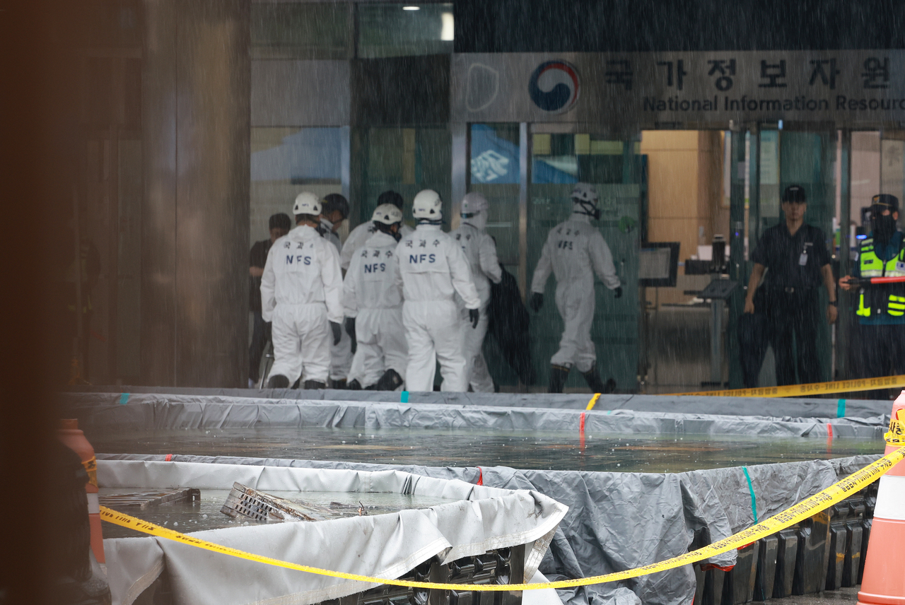 Fire, police authorities, as well as officials from the National Forensic Service, enter the National Information Resources Service in Daejeon on Sunday, two days after a fire forced hundreds of government services offline. (Yonhap)