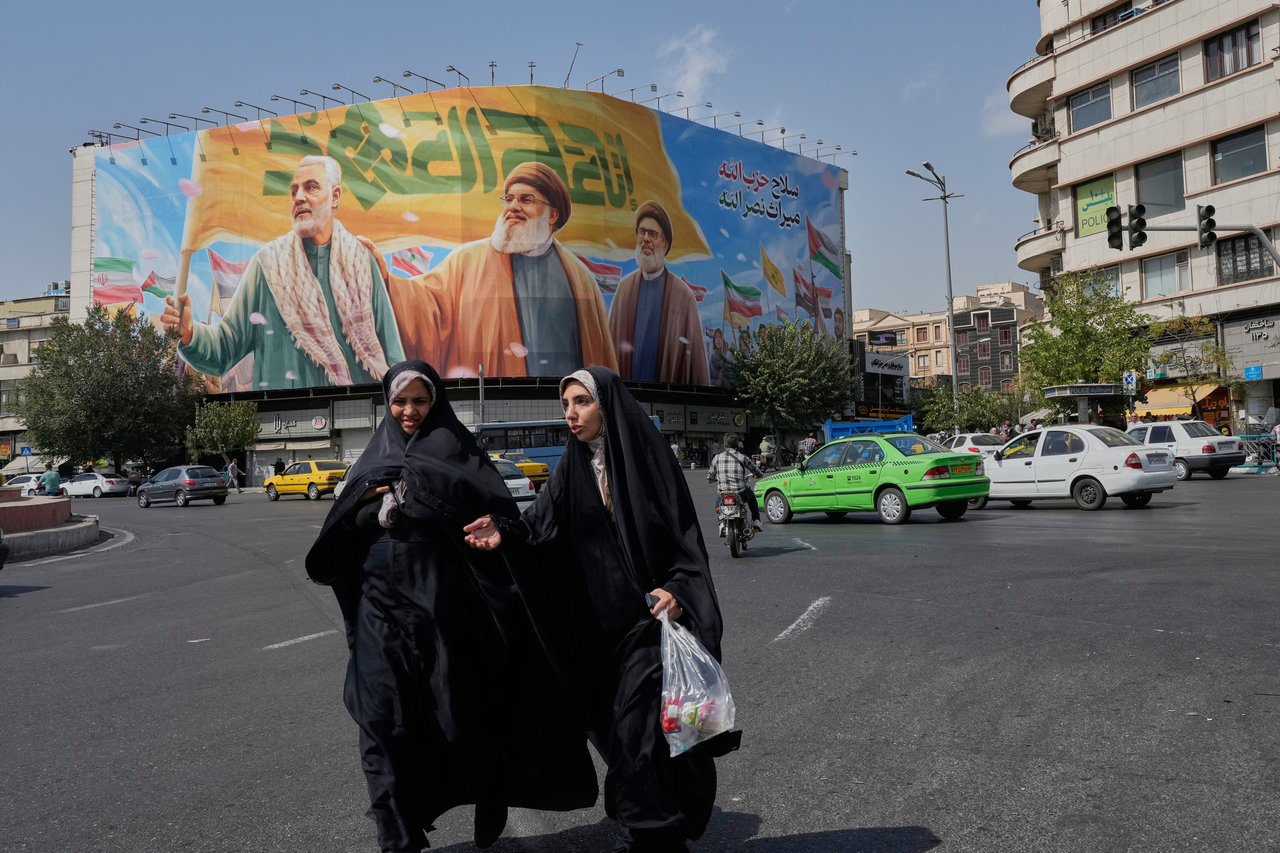 Two women walk past a huge banner at a square in Tehran, Iran, Saturday. (AP-Yonhap)