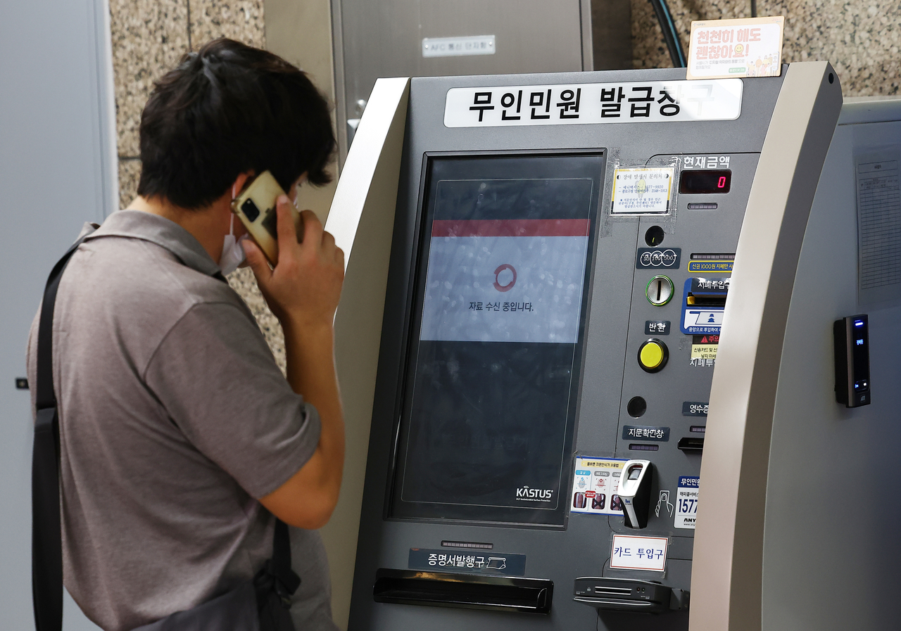A citizen makes a phone call in front of an unmanned civil service kiosk at a Seoul subway station as the service is disrupted on Saturday. (Yonhap)