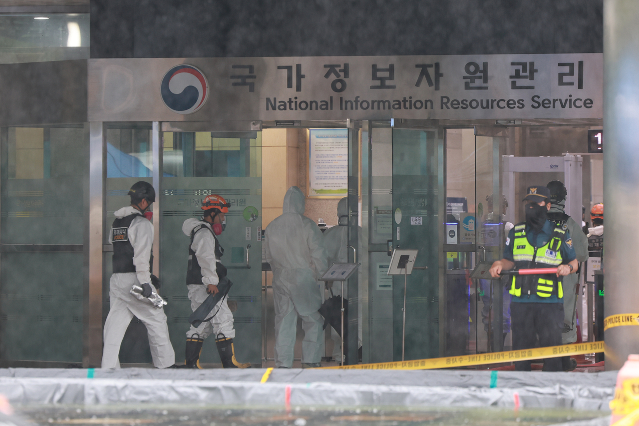 Firefighters, police, and National Forensic Service officials enter the site of a fire at the National Information Resources Service in Daejeon for a joint investigation on Sunday. (Yonhap)