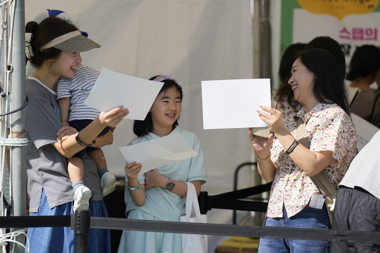 People wait for their turn to participate in the outdoor poetry reading event to set a new Guinness World Record title for "Most people in a reading relay" at Gwanghwamun Square on Saturday. (Seoul Metropolitan Government)