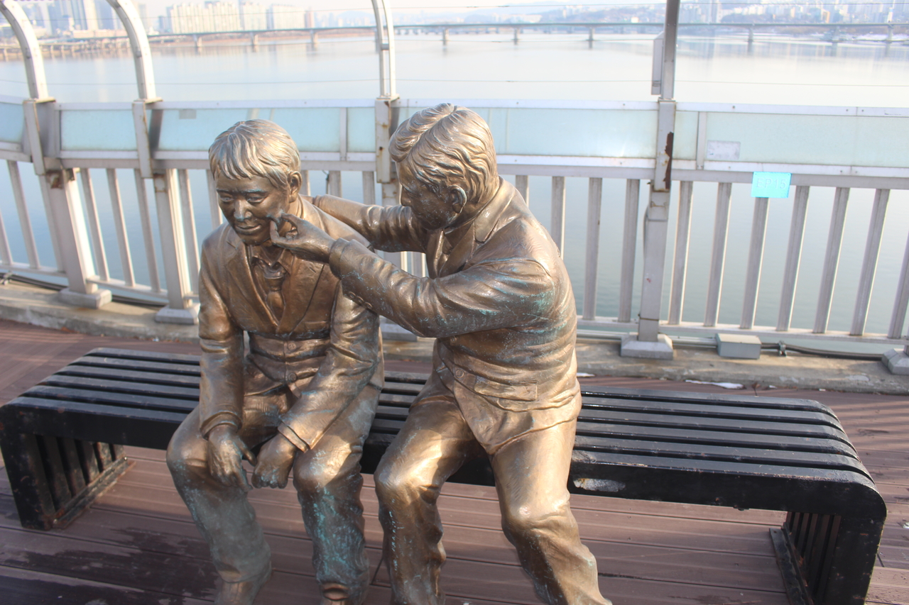 A statue of a man comforting a friend, installed by the Seoul government to discourage those attempting suicide, is seen on Mapo Bridge in Seoul. (Yoon Min-sik/The Korea Herald)
