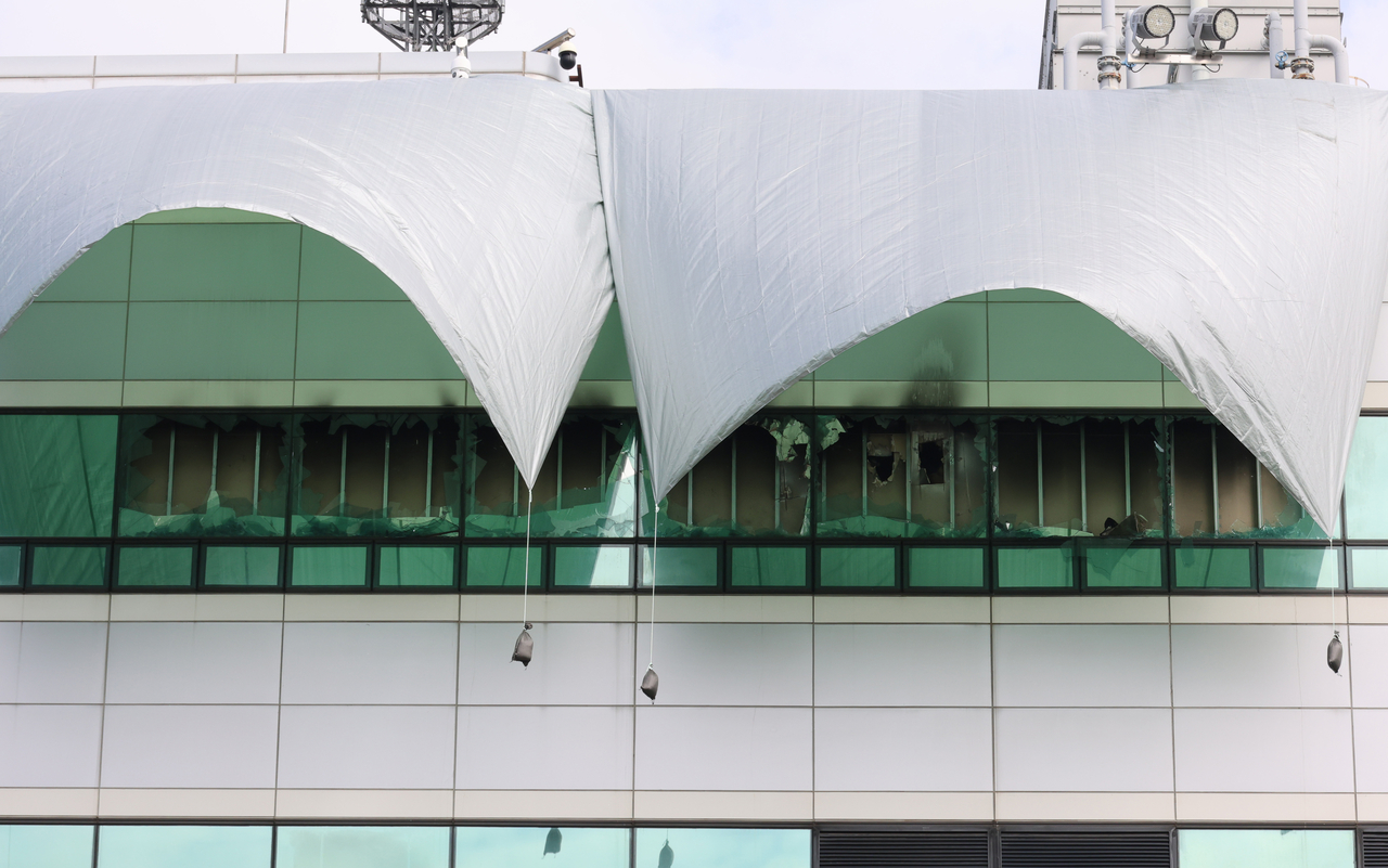 Tarpaulins are hung to cover the shattered windows of a server room at the National Information Resources Service in Daejeon on Monday, two days after a lithium-ion battery fire broke out at the center, causing massive disruptions to government-run systems and administrative services. (Yonhap)