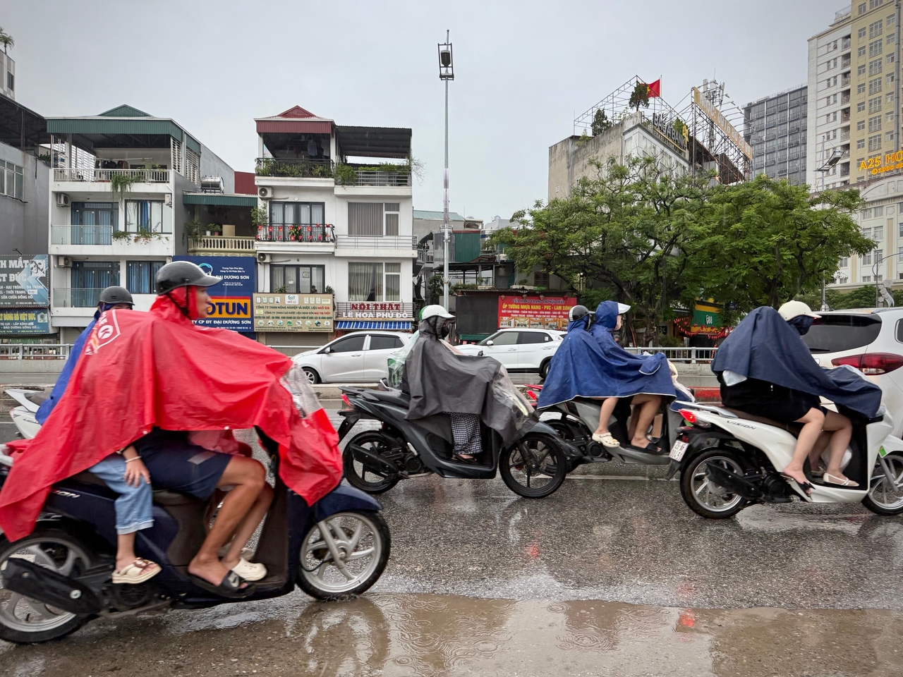 People drive through the rain in Hanoi, Vietnam, Sunday as Typhoon Bualoi brings heavy rains. (AP-Yonhap)