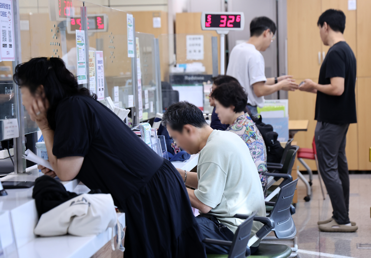 국가정보자원관리원(국정자원) 대전 본원 화재로 전산망 마비 사태가 나흘째 이어지는 29일 서울의 한 주민센터에서 시민들이 업무를 보고 있다. [연합]