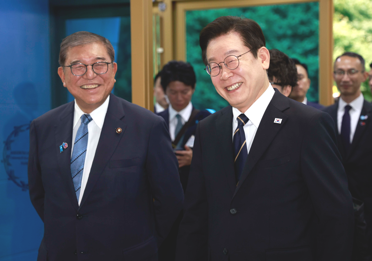 President Lee Jae Myung (right, front) and Japanese Prime Minister Shigeru Ishiba (left, front) enter the Nurimaru APEC House in Busan, where they held their third adn final summit on Tuesday. (Pool photo via Yonhap)