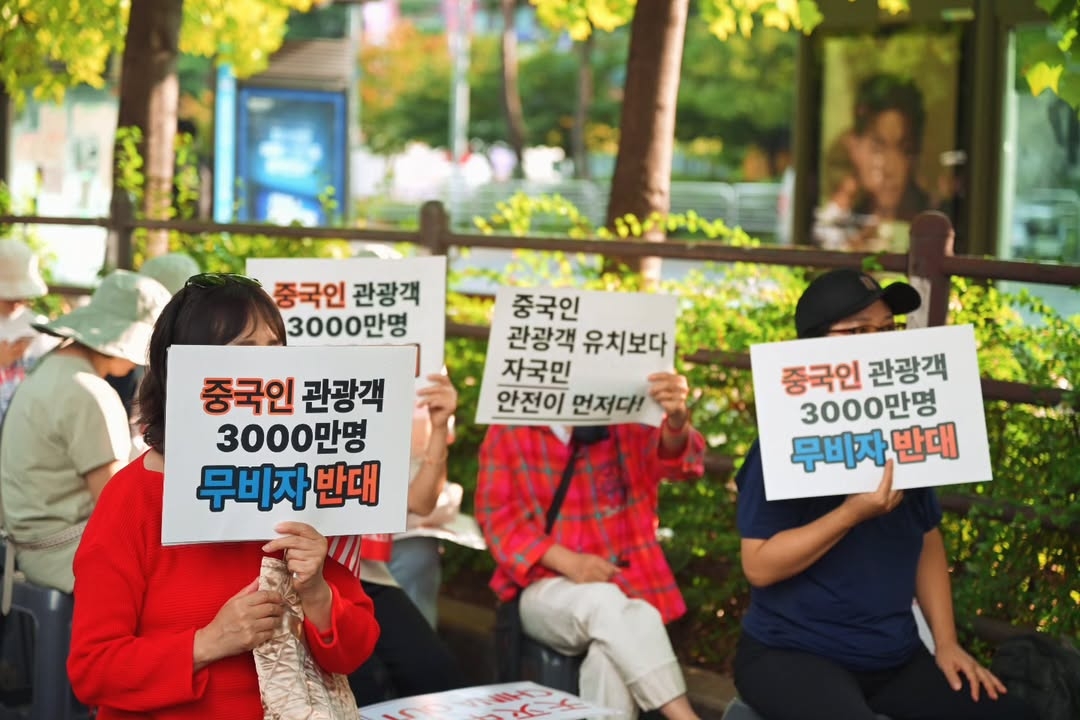 Protesters hold up signs that read "Oppose visa-free entry for 30 million Chinese tourists," "Koreans’ safety comes before attracting Chinese tourists" at the anti-China rally protesting against the visa-free entry of Chinese tourists near the National Assembly in Yeongdeungpo-gu, western Seoul, Monday. (Instagram @gazeofyouth)