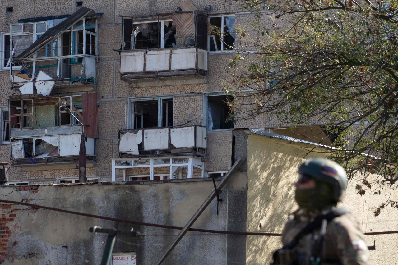 A Russian military police officer stands next to a damaged residential building in Kurakhove, Russian-controled Donetsk region of Ukraine on Saturday. (AFP-Yonhap)