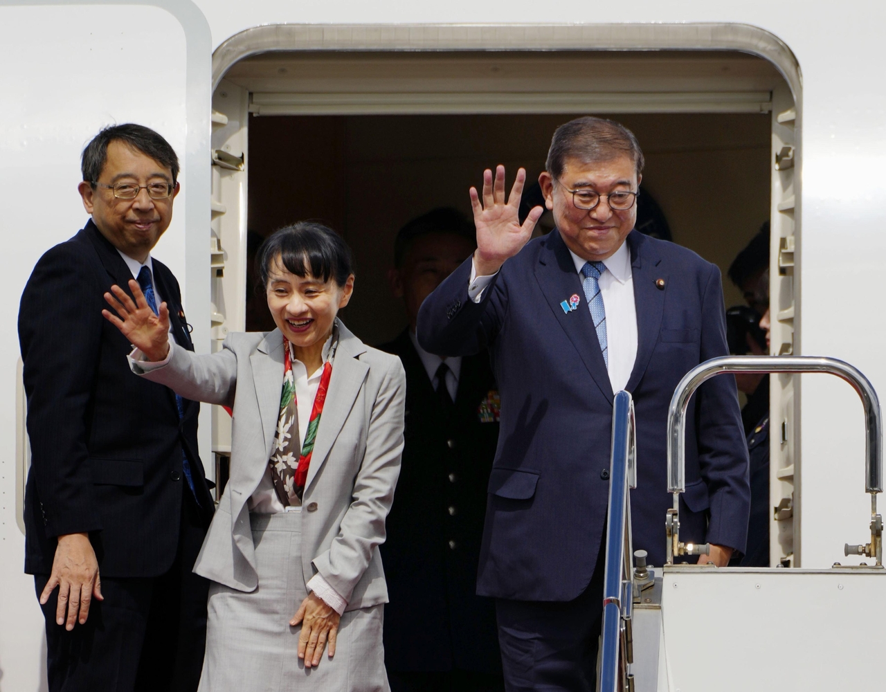 Japanese Prime Minister Shigeru Ishiba (right) and his wife Yoshiko Ishiba (center) depart Haneda International Airport in Tokyo to fly to Busan on Tuesday. (Yonhap)
