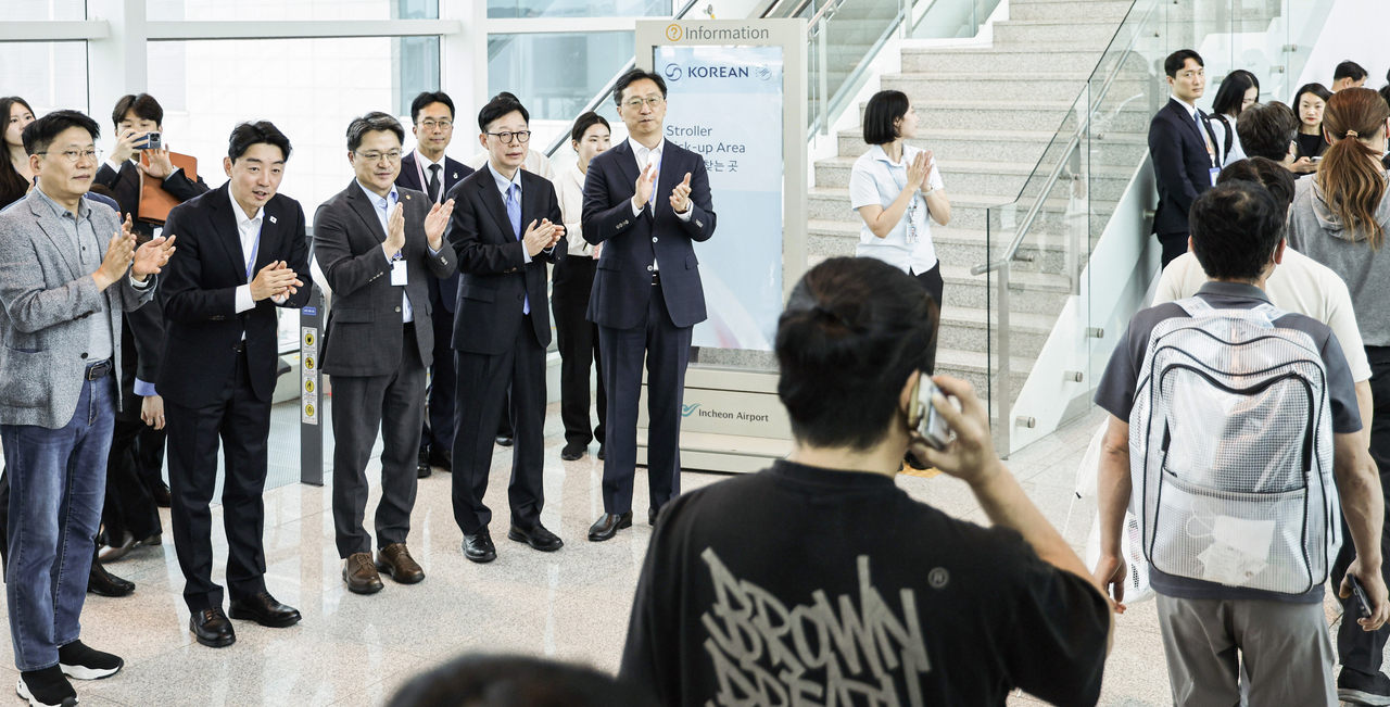 The 316 South Korean workers released from detention by US immigration authorities are greeted by government officials on arrival at Incheon Airport on Friday. (Yonhap)