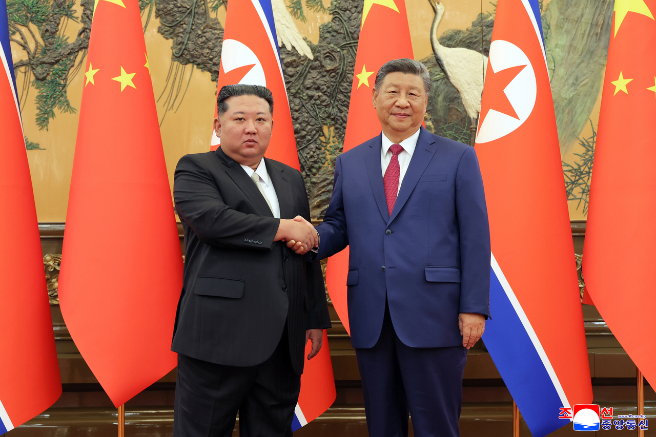 This photo, published by North Korea's Korean Central News Agency on Sept. 5, 2025, shows leader Kim Jong-un (left) shaking hands with Chinese President Xi Jinping during their talks the previous day. (Yonhap)