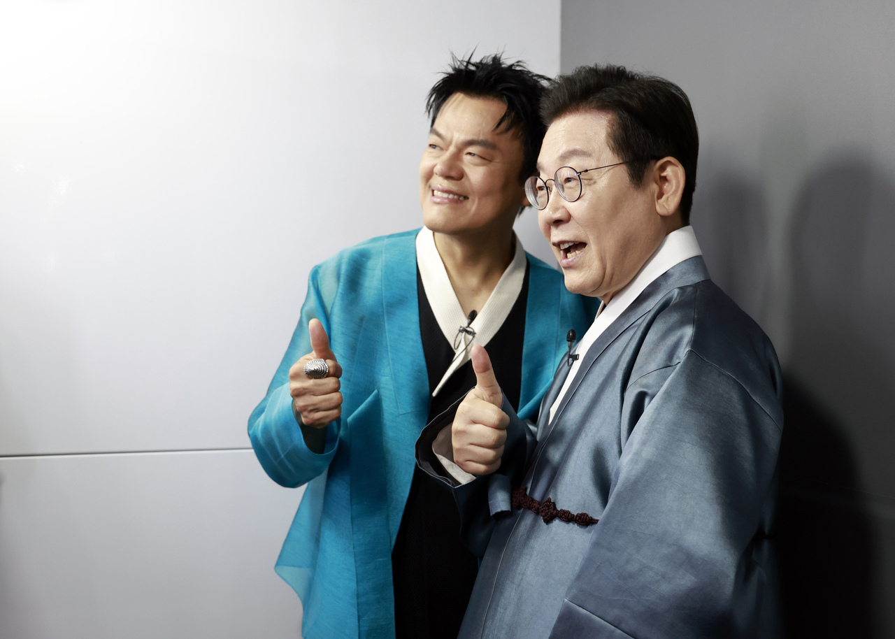 President Lee Jae Myung (right) poses for a photo with J.Y. Park, co-chair of the Presidential Committee on Popular Culture Exchange, at a K-culture experience zone during the commission’s inaugural ceremony at Kintex in Goyang, Gyeonggi Province, Oct. 1. (Yonhap)
