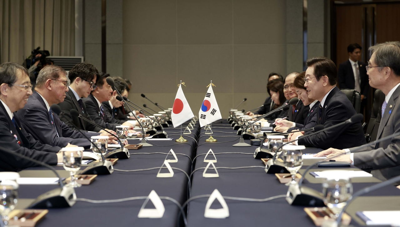 President Lee Jae Myung (second from right) and Japanese Prime Minister Shigeru Ishiba (second from left) hold extended summit talks at the Nurimaru APEC House in Busan on Tuesday. (Yonhap)