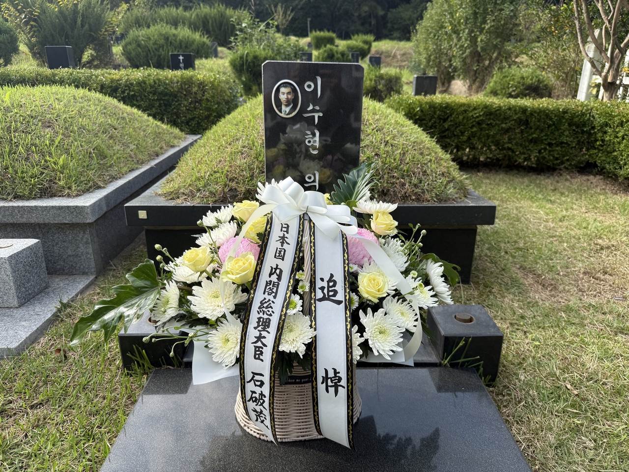 Flowers left by Japanese Prime Minister Shigeru Ishiba are displayed at the grave of Lee Soo-hyun, a Korean who died while trying to save the life of a Japanese man in 2001, in Busan's Yeongnak Park, Tuesday afternoon. (Yonhap)