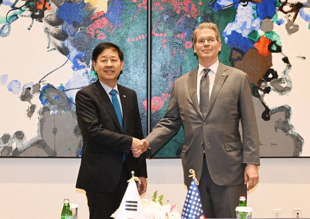 Finance Minister Koo Yun-cheol (left) shakes hands with US Treasury Secretary Scott Bessent during their meeting in New York on Sept. 24, 2025, in this photo provided by Koo's office. (Yonhap)