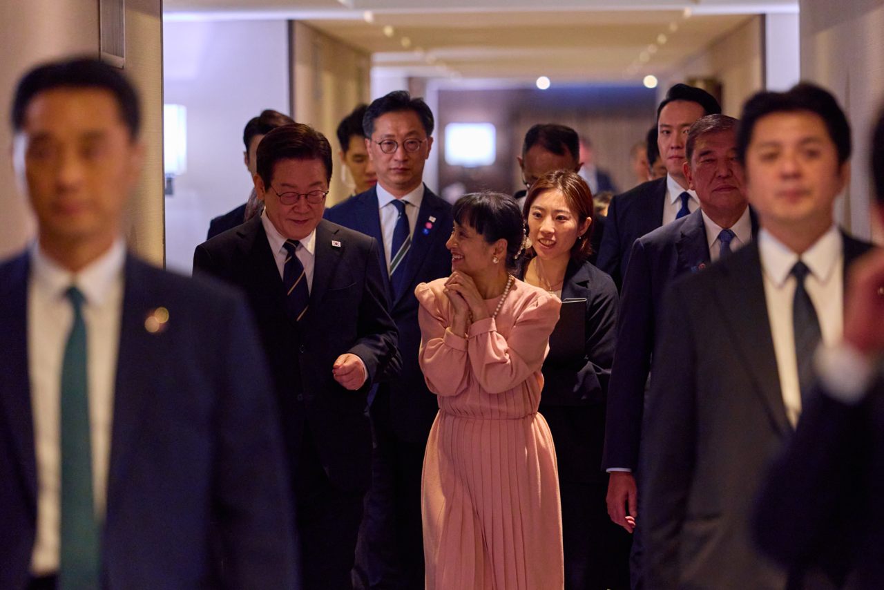 President Lee Jae Myung (second from left), Japan's Prime Minister Shigeru Ishiba (second from right) and his wife Yoshiko (in pink) walk to an event at the Westin Chosun in Busan, Tuesday evening. (Yonhap)