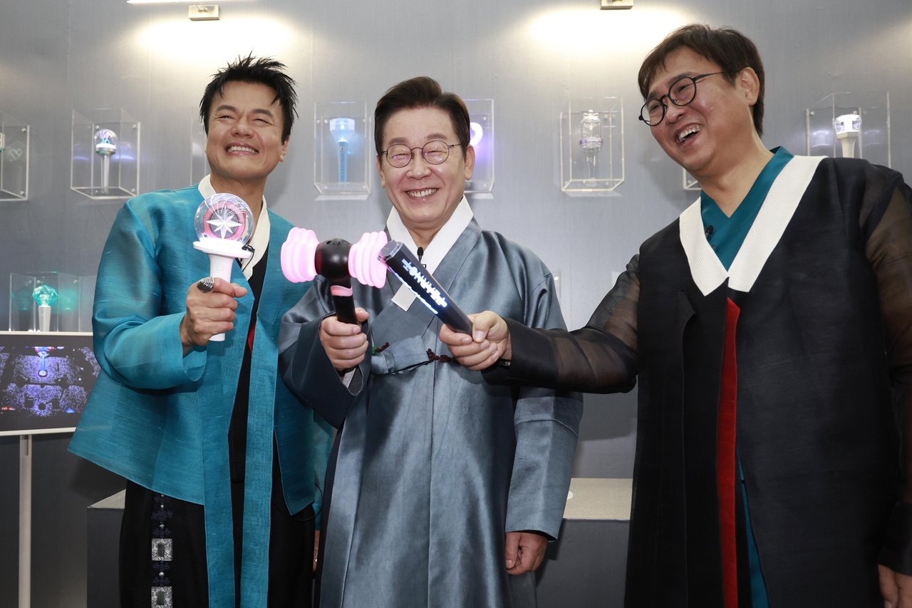 이재명(가운데) 대통령이 1일 경기 고양시 킨텍스에서 열린 대중토토사이트 로그인교류위원회 출범식에서 박진영(왼쪽)·최휘영 대중토토사이트 로그인교류위원회 공동위원장과 K컬처 체험존에서 응원봉을 들고 기념촬영을 하고 있다. [연합]