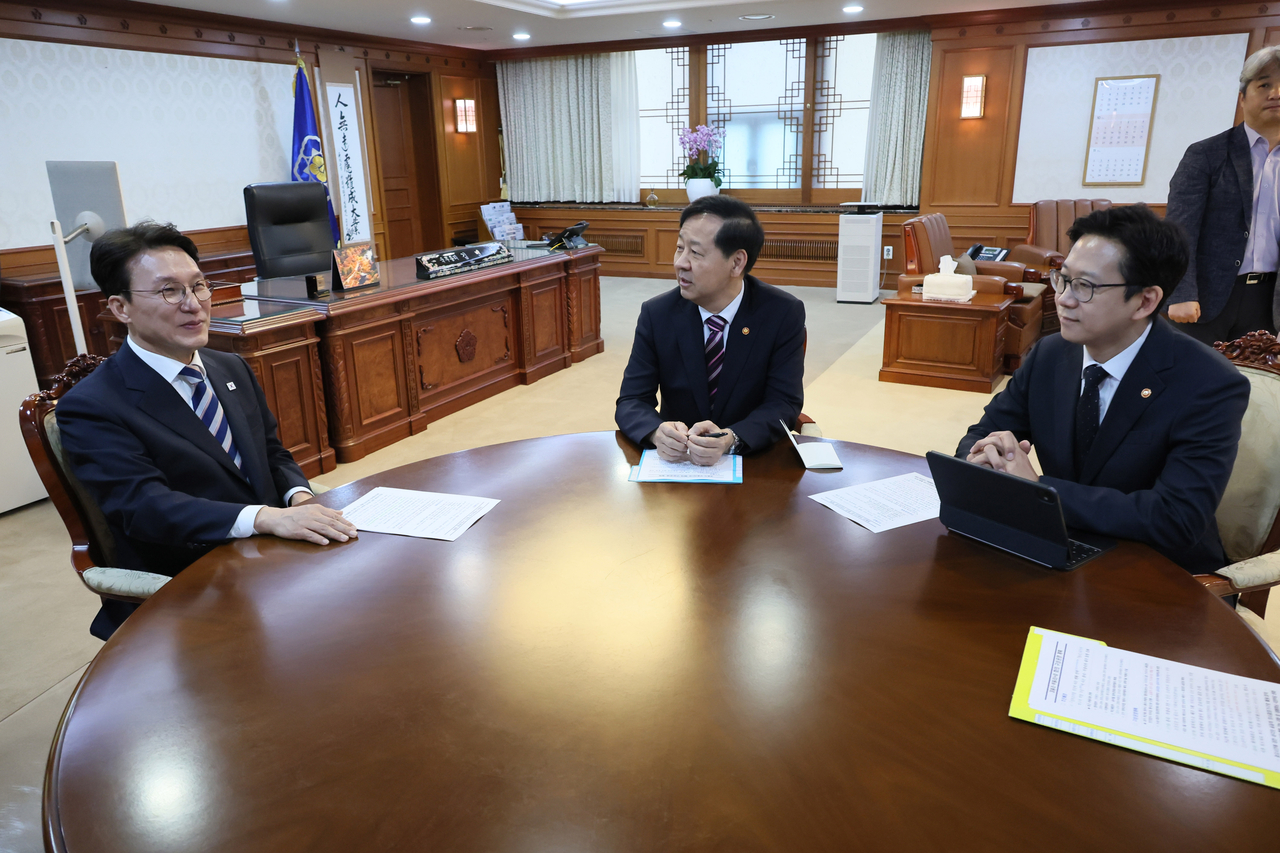 Prime Minister Kim Min-seok (L) talks with Finance Minister Koo Yun-cheol (C), who serves concurrently as deputy prime minister for economic affairs, and Science and ICT Minister Bae Kyung-hoon, who doubles as deputy prime minister for science affairs, during their meeting at Kim's office in Seoul on Thursday. (Yonhap)
