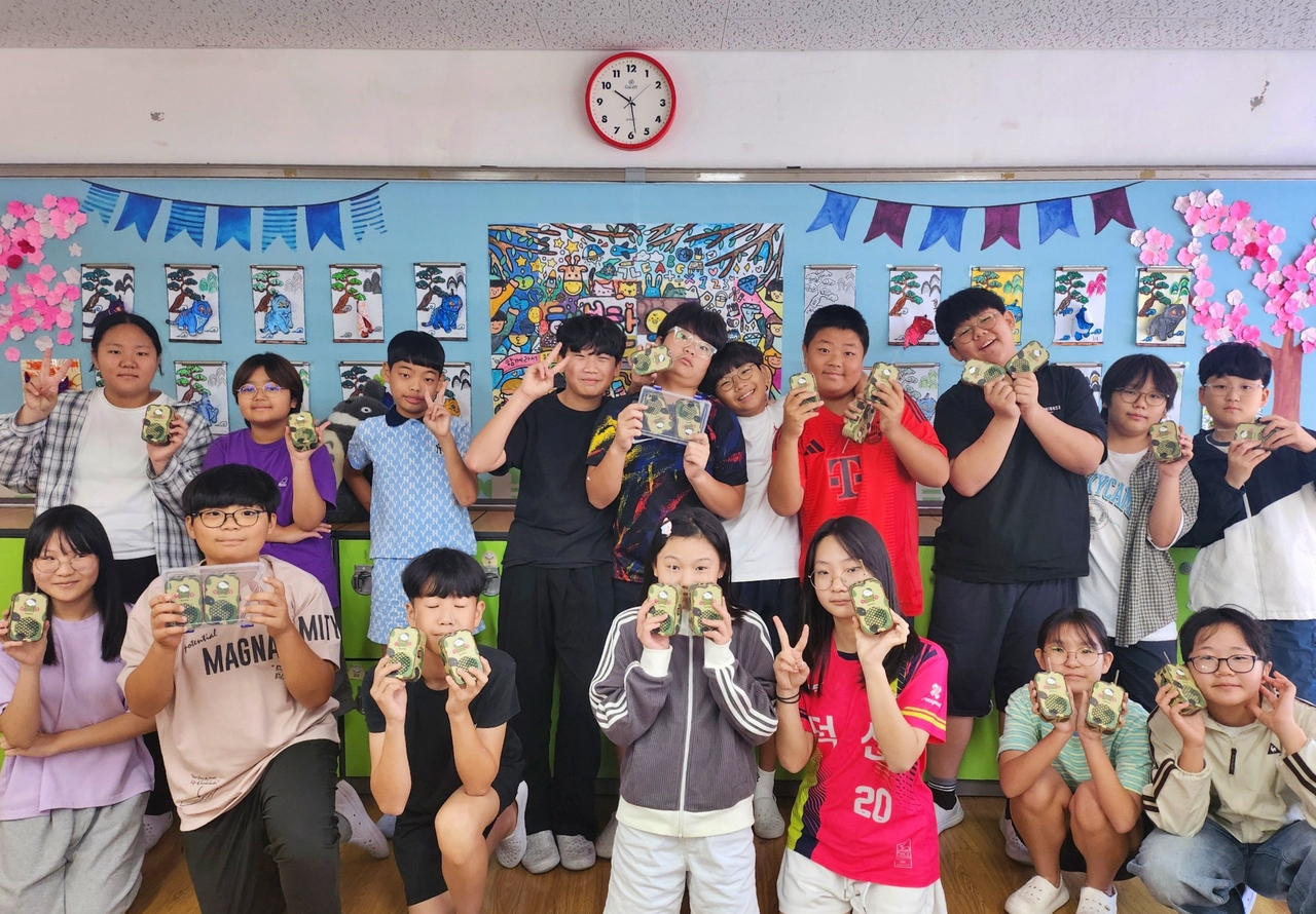 울산 덕신초등학교 주니어 해외 토토사이트 순의 특별수업에서 학생들이 직접 만든 무전기를 들고 기념 촬영을 하고 있다. [고려아연 제공]