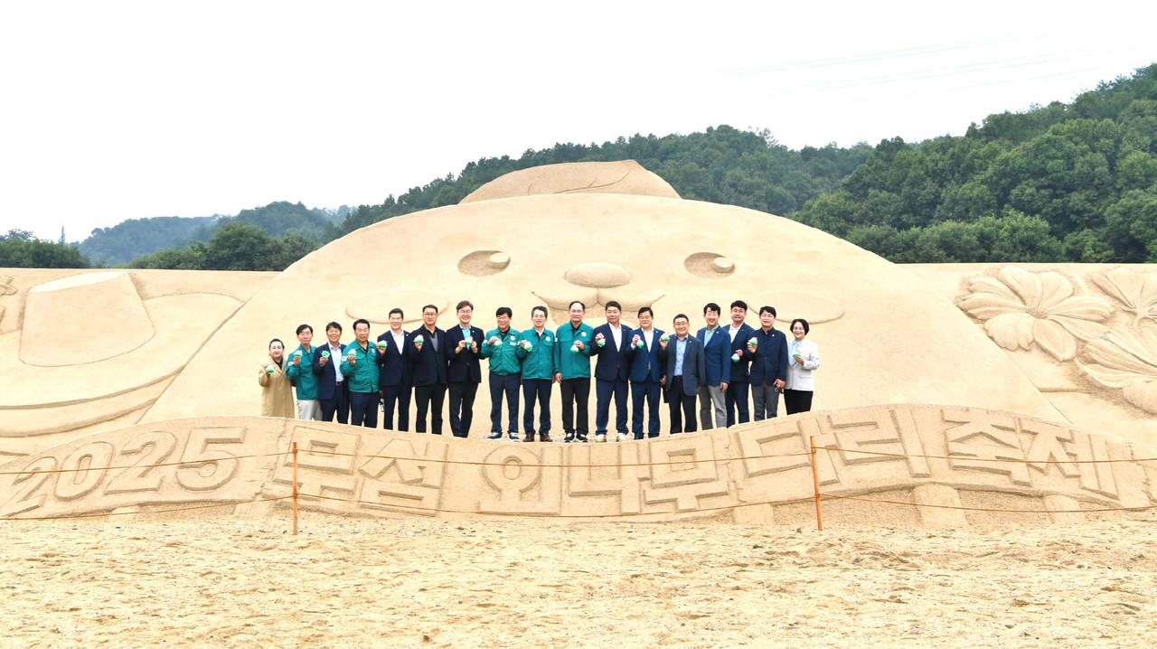 샌드아트 조형물 앞에서 2025영주 무섬외나무다리 축제 개막식에서 유정근 영주시장 권한대행, 임종득 국회의원, 김병기 시의회 의장, 도.시의원등이 단체 기념사진을 찍고 있다.[영주시 제공]