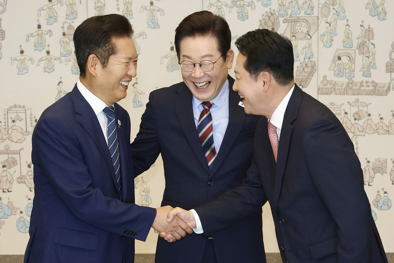 이재명 대통령이 지난달 8일 용산 대통령실에서 여야 지도부 오찬 회동에 참석한 정청래 더불어민주당 대표와 장동혁 국민의힘 대표가 악수하는 모습을 보고 있다. [연합]