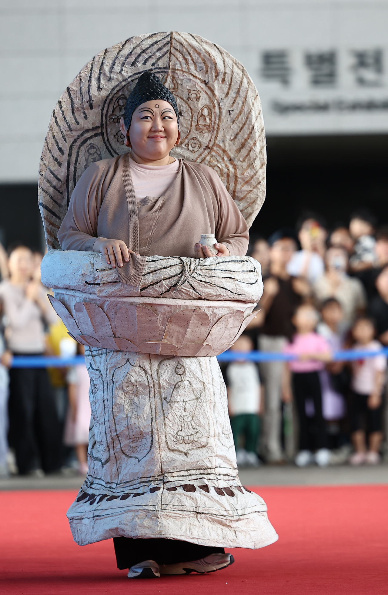 A participant walks in dressed as a seated stone Buddha statue. (Yonhap)
