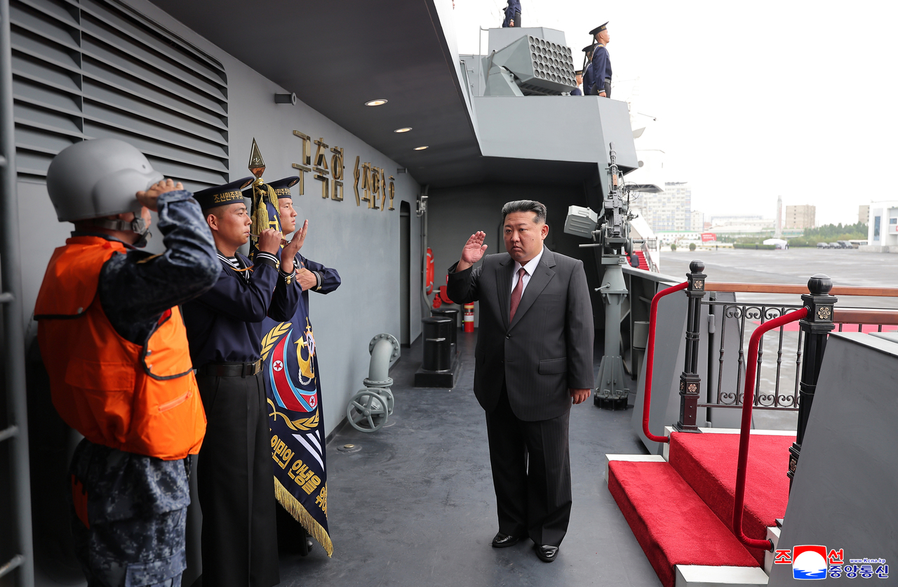 This photo, carried by North Korea's official Korean Central News Agency on Monday, shows the North's leader Kim Jong-un (right) visiting the 5,000-ton destroyer, named the Choe Hyon, the previous day.  (KCNA-Yonhap)