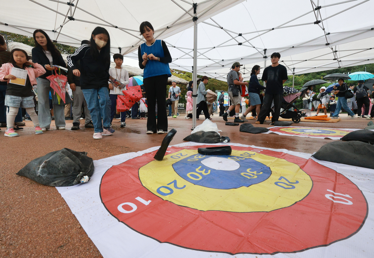 Citizens enjoy the traditional shoe-throwing game at Namsangol Hanok Village in central Seoul on Monday. (Yonhap)